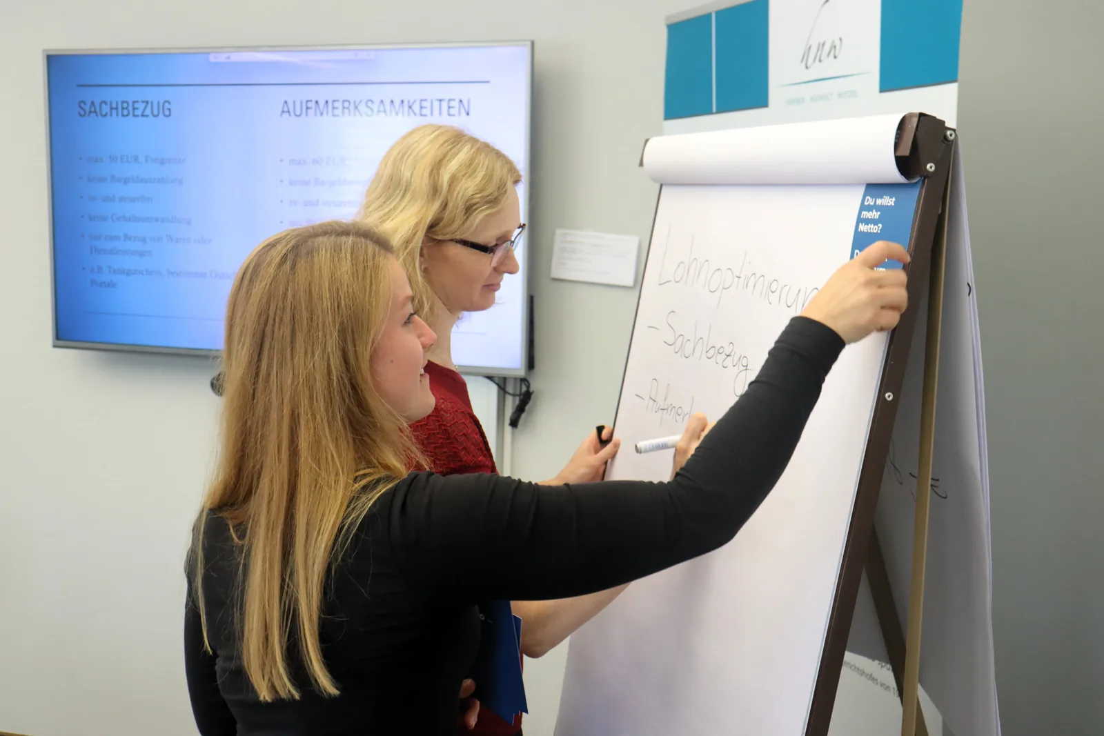 Zwei Mitarbeiterinnen erarbeiten am Flipchart Möglichkeiten der Lohnoptimierung – HNW GmbH StBG